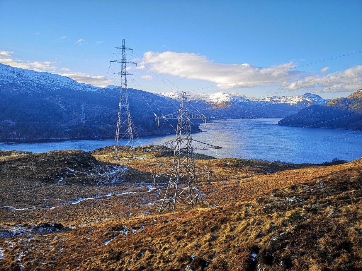 Towers on the hills on a crips day next to the water.