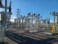 Substation infrastructure within a fenced area.