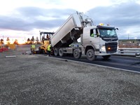 Contractors driving a series of road surfacing vehicles.