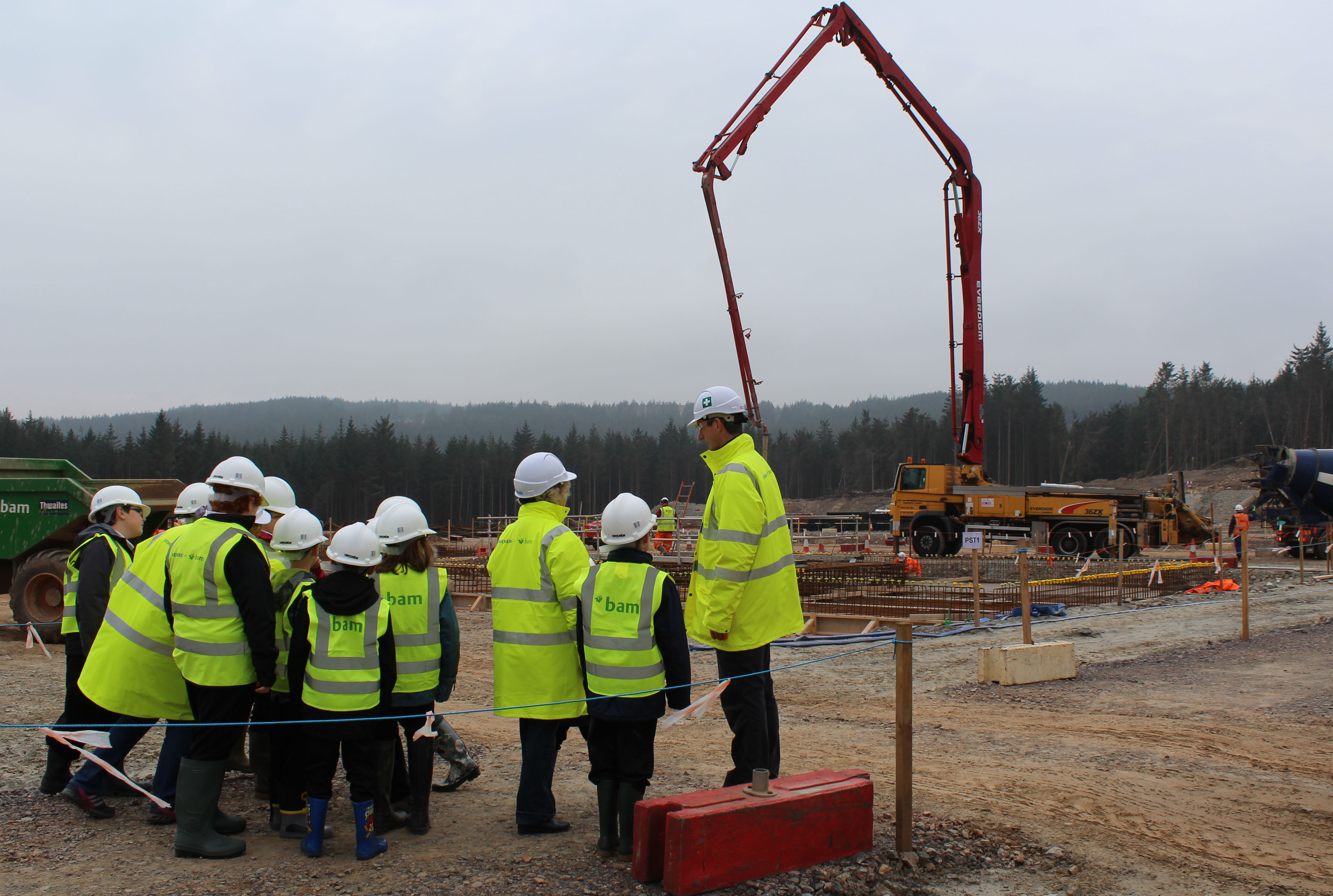 An SSEN Transmission employee in PPE with several children also in PPE.