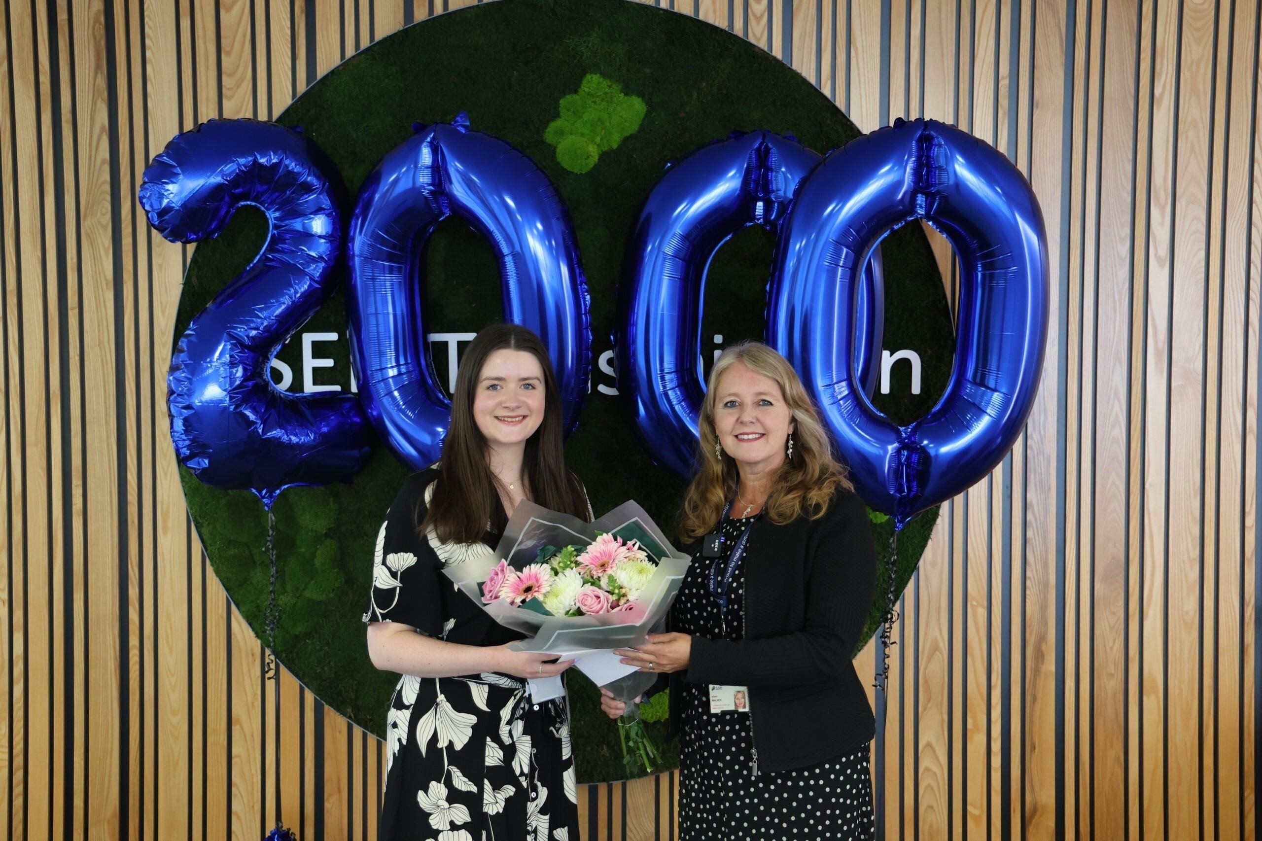 Catherine Cowie (left) receives a welcome gift from SSEN Transmission's HR Business Partner Allie Walker for becoming the 2,000th team member.